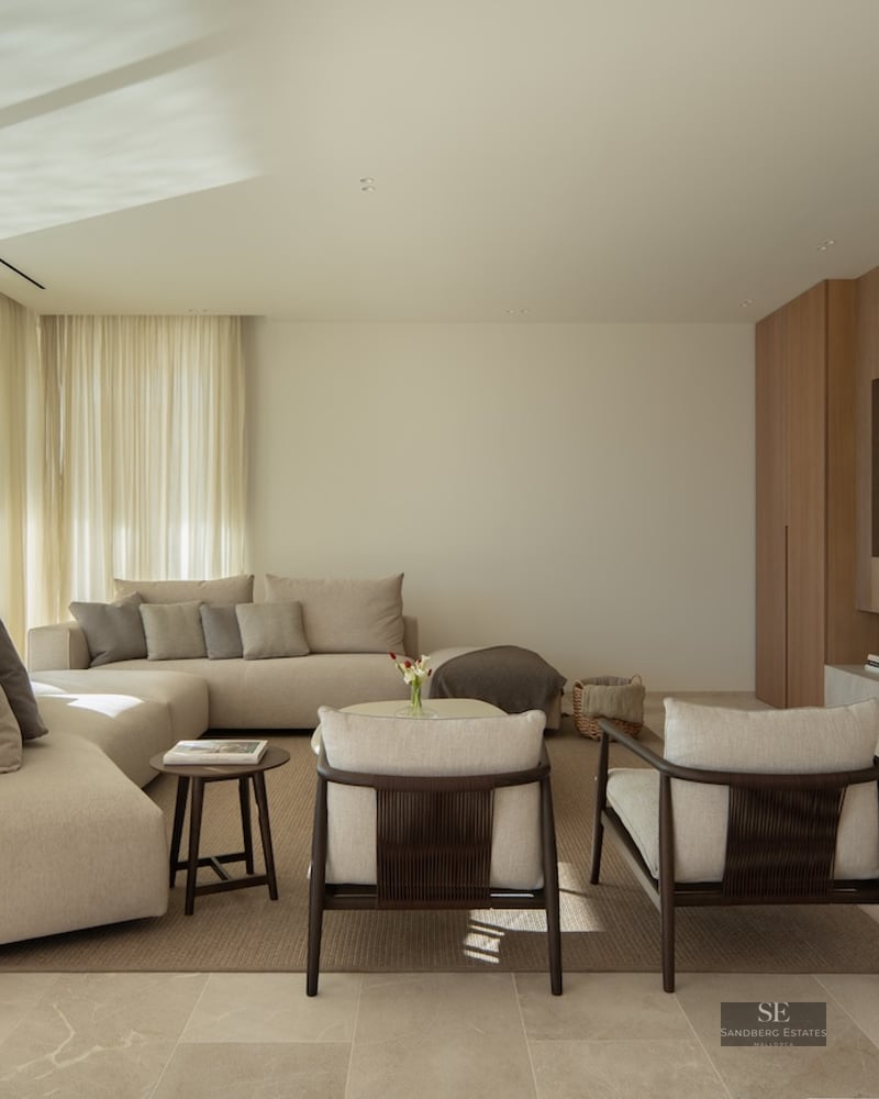 Modern living room with a beige sectional sofa, wood paneled TV wall, and floor-to-ceiling windows with a scenic view.