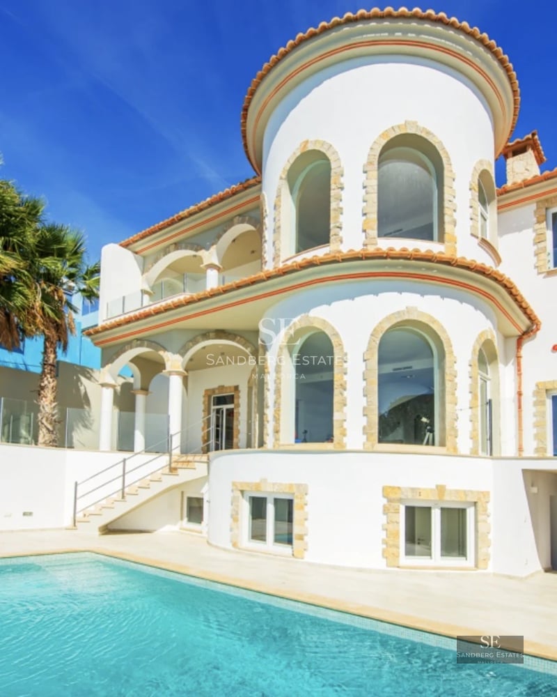 Bright living room with large windows, modern sofas, soft rug, and panoramic view. Elegant and comfortable design.