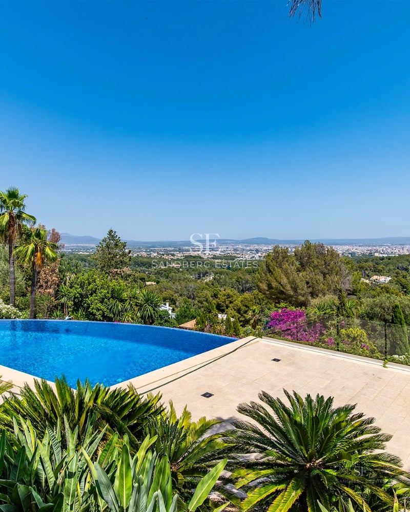 Wide view of modern villa featuring an infinity pool, sea views, minimalist design, large terraces and elegant outdoor furniture.