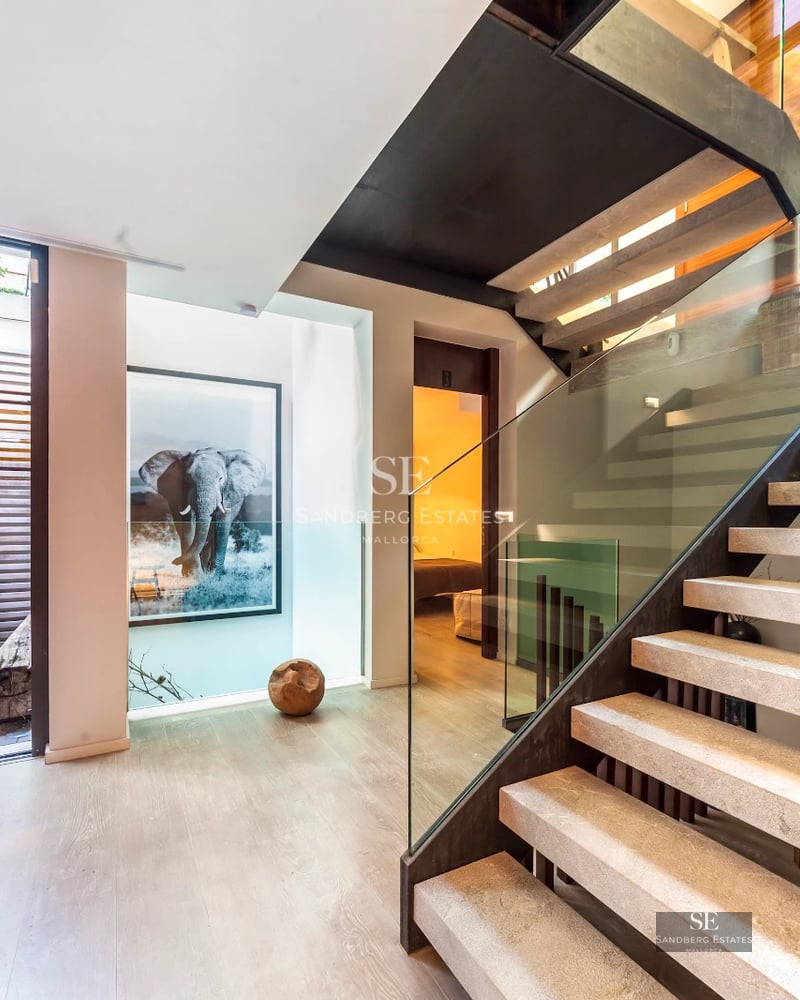 View of a modern villa with infinity pool and lush garden. Minimalist architecture with large windows and high-end materials.