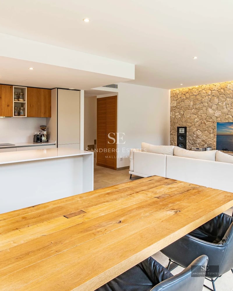 Bright living room with large windows, beige sofa, modern fireplace, and panoramic views. Minimalist and elegant design.