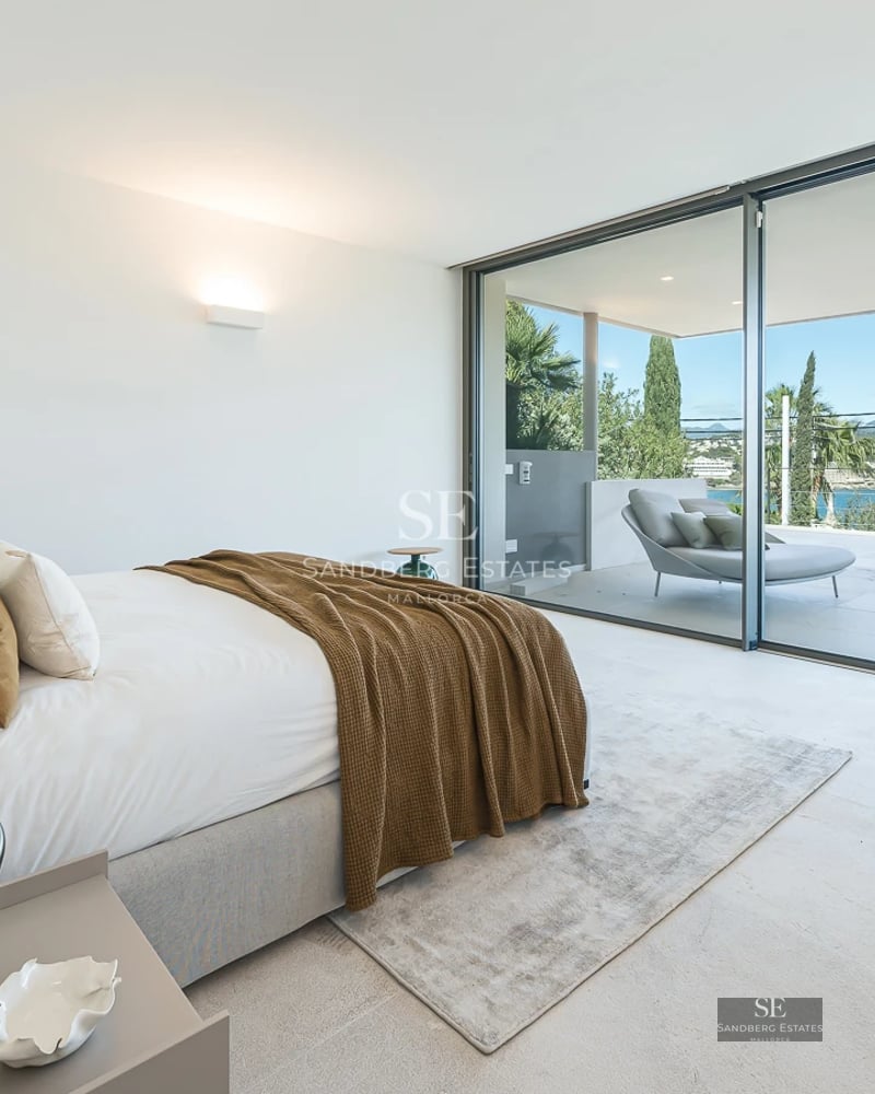 Bright interior with sea views. Modern design, light wood floors, large windows, and elegant furniture.