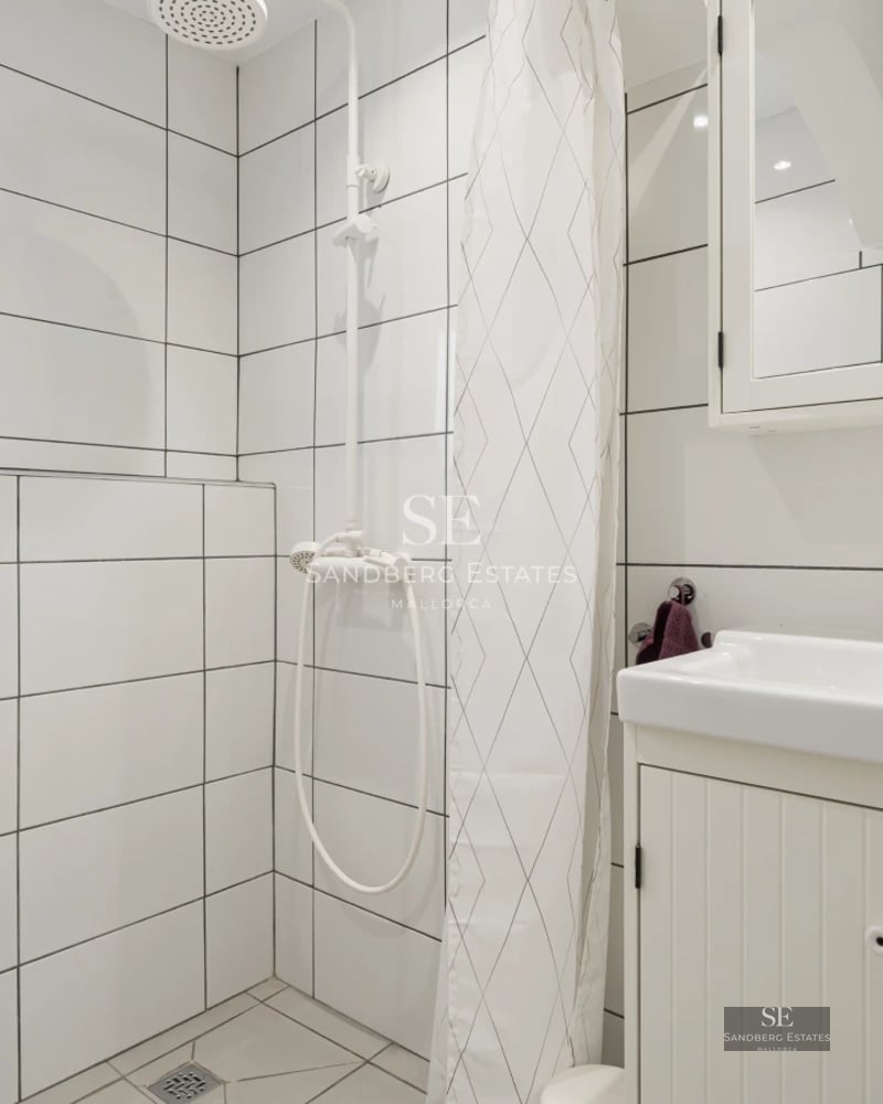 Exterior view of a modern villa featuring an infinity pool, large windows, and a minimalist design. Lush garden and blue skies.