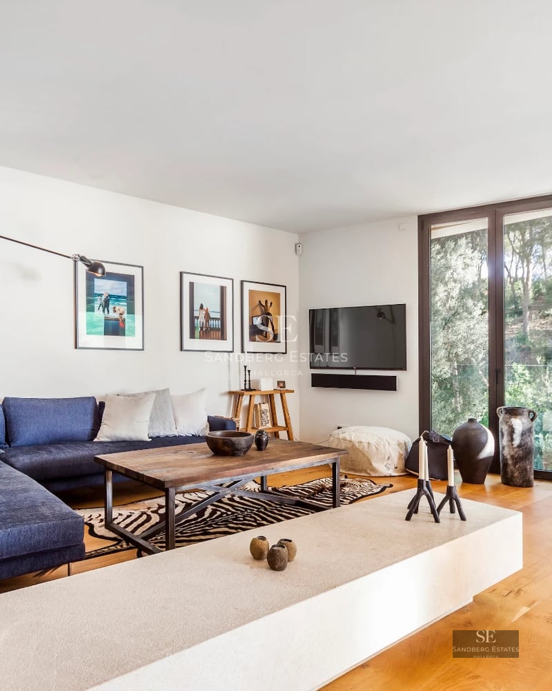 Exterior view of a modern villa featuring an infinity pool, lush garden, and expansive terraces. Minimalist architecture with large windows.