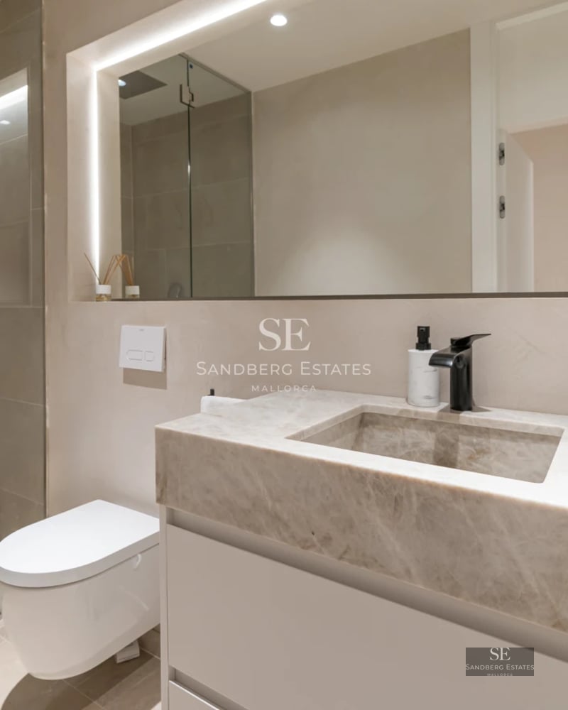 Spacious balcony with sea view, glass railing, modern furniture, wood flooring. Minimalist and bright design.