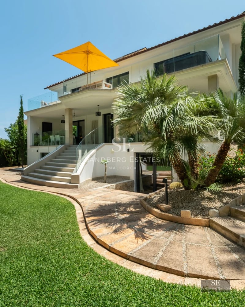 Bright living room with large windows, wood floor, modern sofas and stunning sea views. Elegant and contemporary design.