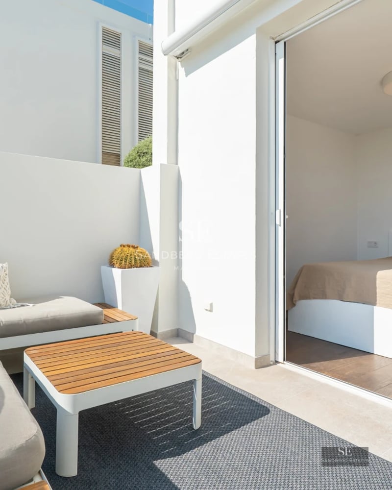 View of infinity pool with terrace and lush greenery. Modern architecture with large windows. Elegant exterior design.