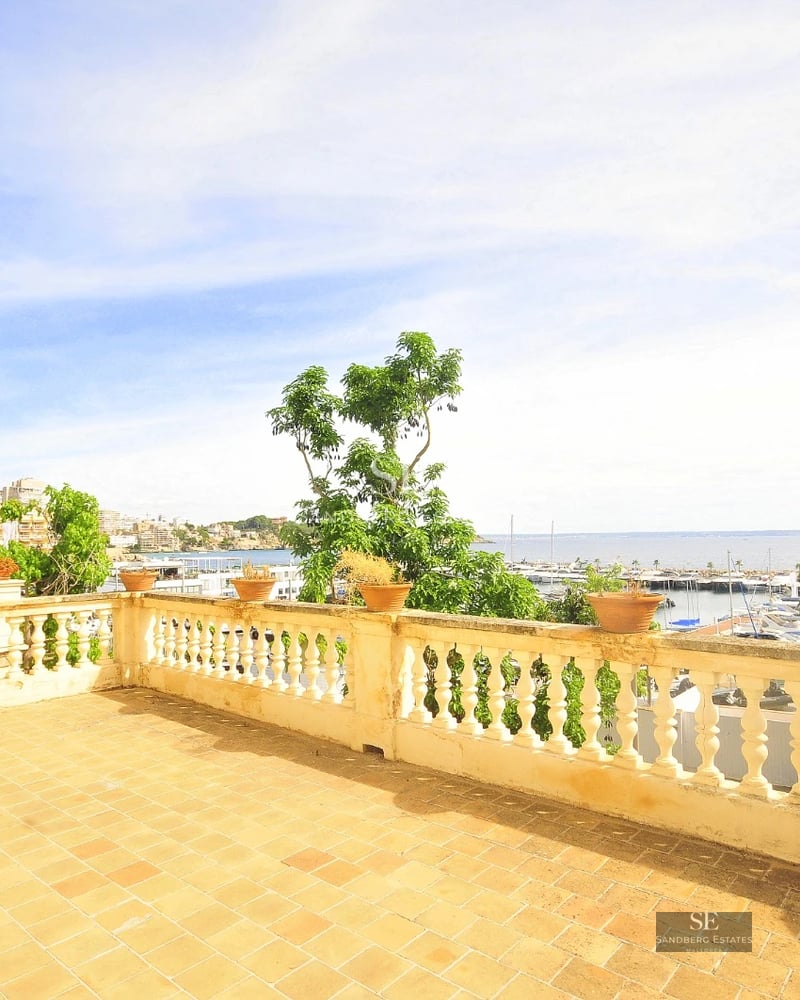 Spacious balcony with panoramic sea views. Modern design, glass railing, and elegant outdoor furniture.