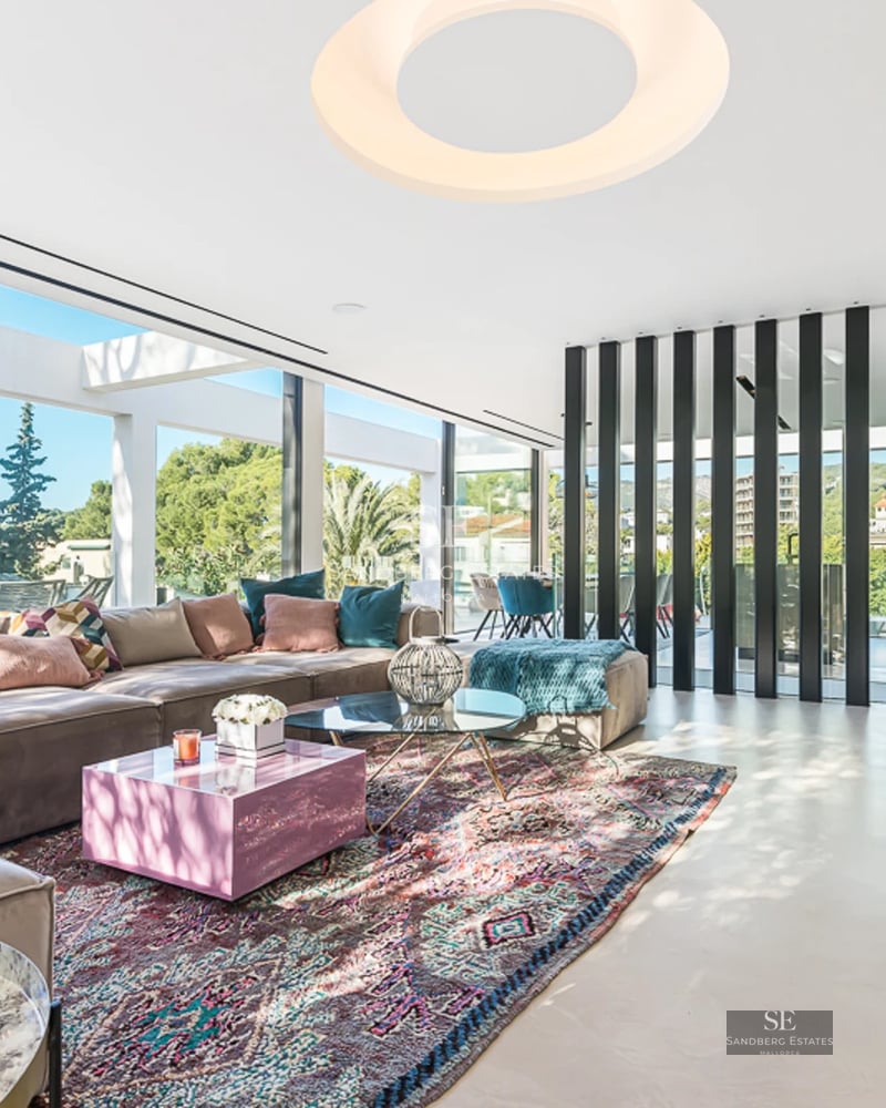 Spacious balcony with panoramic views. Glass railing, outdoor furniture, and abundant natural light. Modern and elegant design.