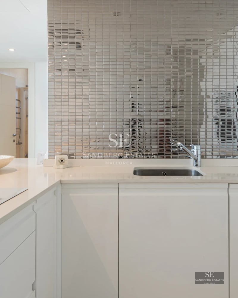 Spacious living room with panoramic windows, light wood flooring, minimalist design furniture, and garden views. Natural lighting.