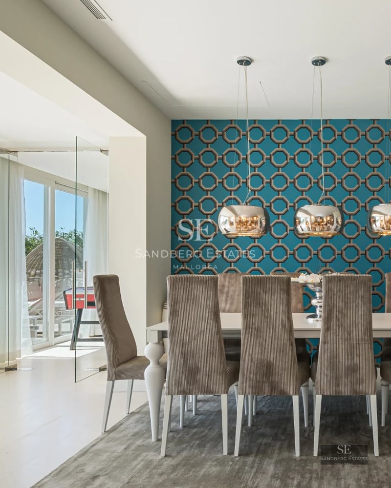 Wide view of bright living room with balcony and sea view. Modern furniture in neutral tones. Light wood flooring.