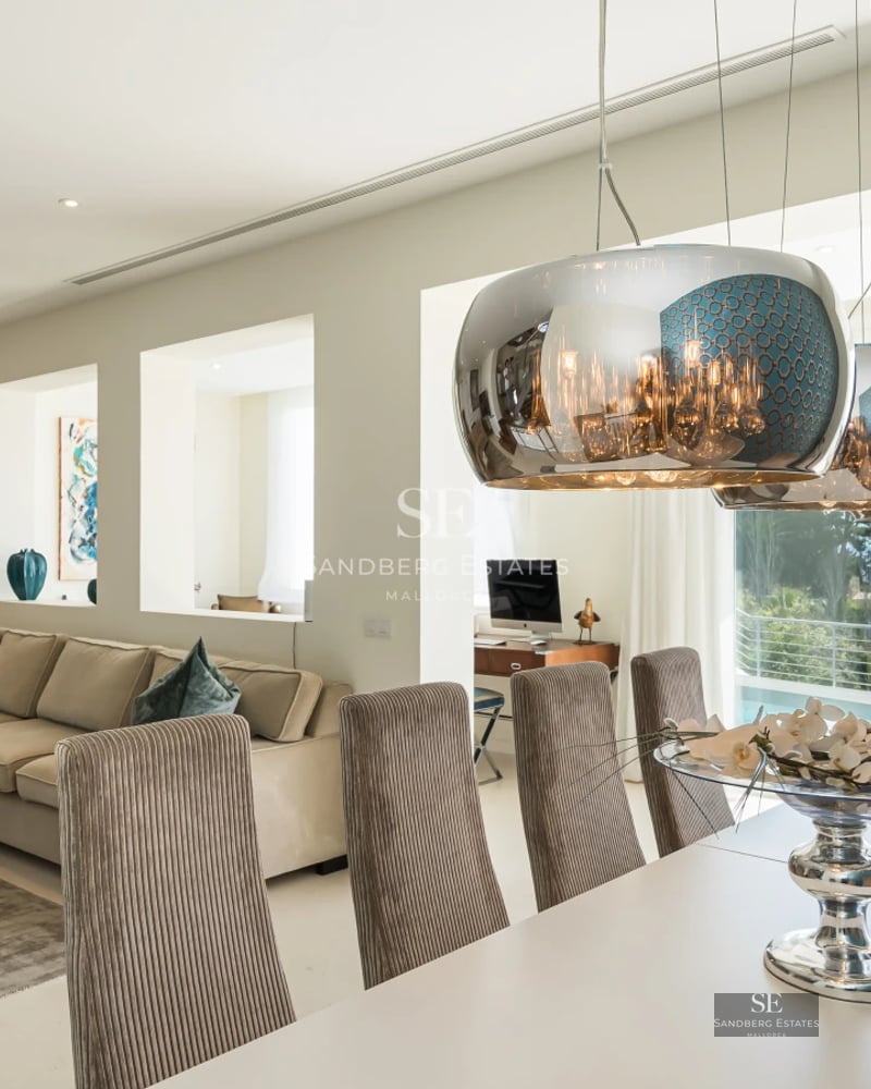 View of a luxurious villa featuring an infinity pool, lush gardens, and modern architecture. Natural lighting.