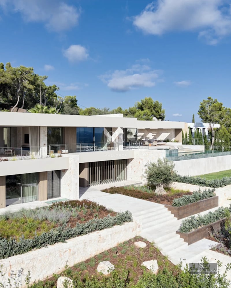 View of garden with infinity pool, sun loungers, and lush vegetation. Modern and relaxing design.