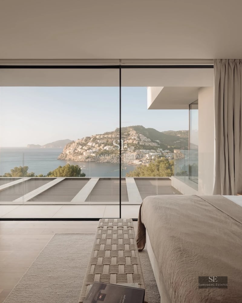 Spacious living room with panoramic sea views. Modern design, light wood floors, and minimalist furniture in neutral tones.