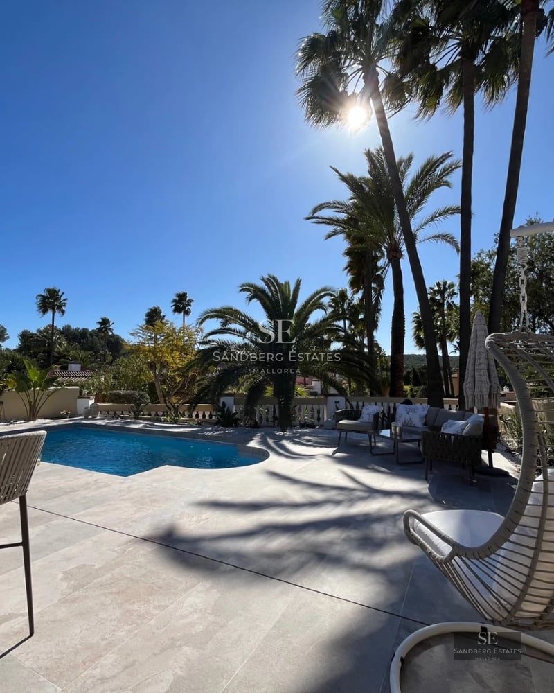 Exterior view of a modern home with a pool, lush garden, and large windows that maximize natural light.