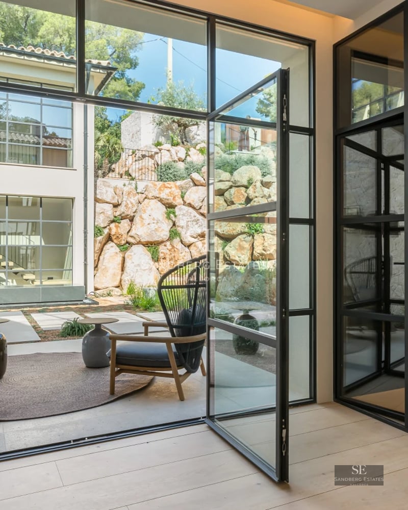 Pool view with terrace and modern armchairs, surrounded by lush greenery. Minimalist design, soft lighting and relaxing atmosphere.