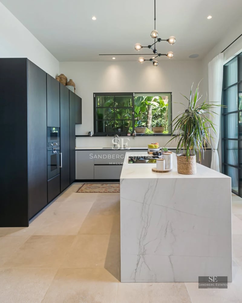 Salon spacieux avec baies vitrées offrant une vue sur la mer. Design moderne, lumière naturelle, parquet et mobilier élégant. Vues panoramiques.