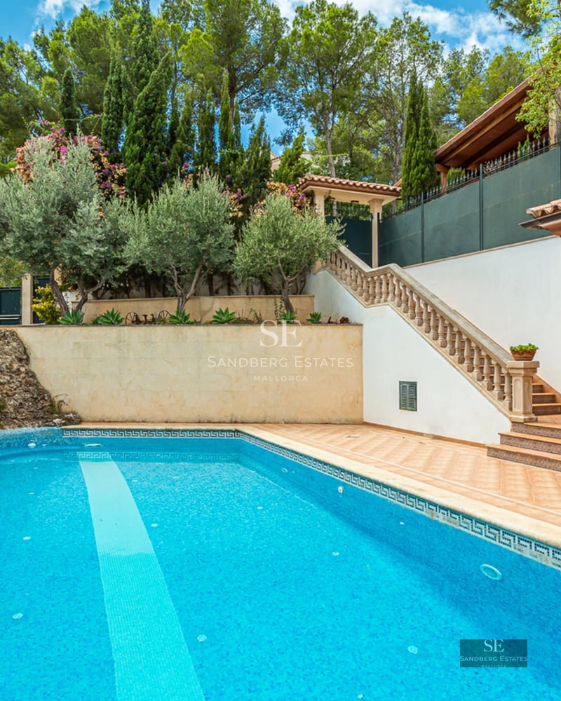 Exterior view of a modern villa featuring an infinity pool, expansive terraces, and lush garden. Contemporary architectural design.