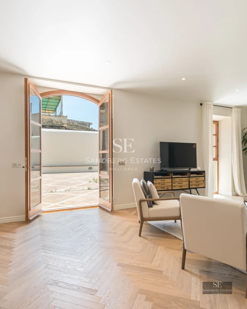 Bright living room with large windows, modern furniture, light wood flooring, and spectacular sea views. Elegant and functional design.