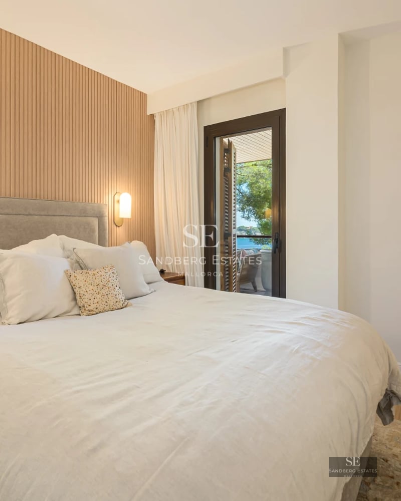 View of a luxurious pool with loungers and umbrellas, surrounded by a manicured garden. Modern and elegant architecture.