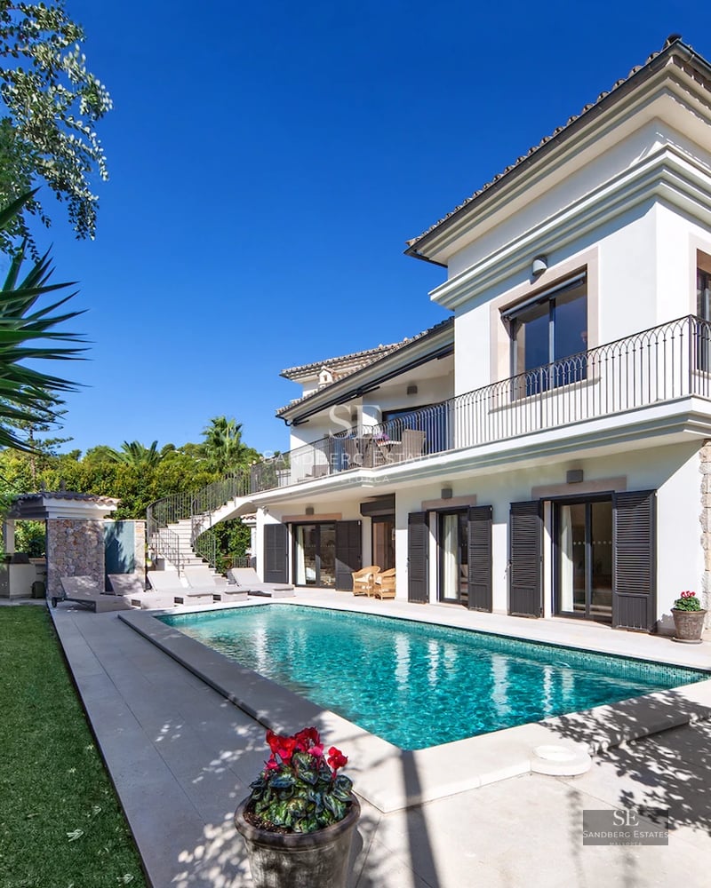 Spacious living room with large windows, reflecting pool, and minimalist design. Elegant interior with abundant natural lighting.