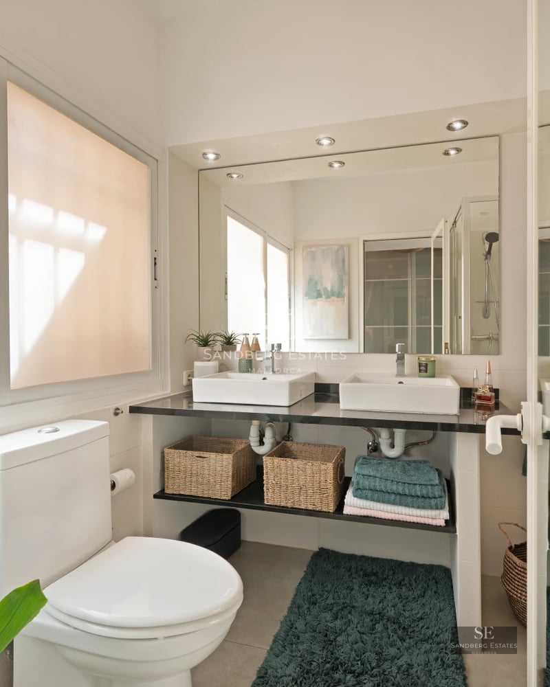 Panoramic view of a modern living room with large windows offering stunning sea views and access to a terrace.