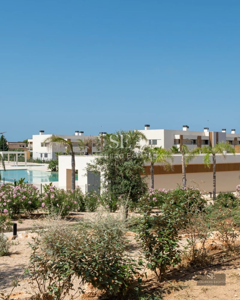 Aerial view of a luxurious modern villa featuring an infinity pool, expansive gardens, and minimalist architectural design.