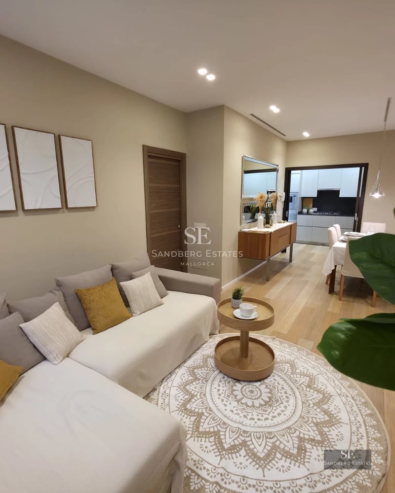 Exterior view of a modern villa with infinity pool, wooden deck, and large glass windows. Lush garden with tropical vegetation.