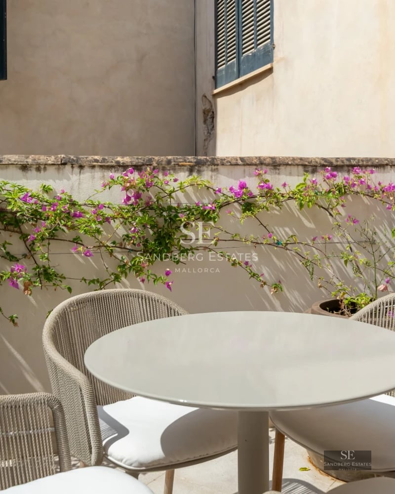 Bright living room with panoramic sea views. Beige sofa, light walls, large window, balcony. Modern and elegant interior design.
