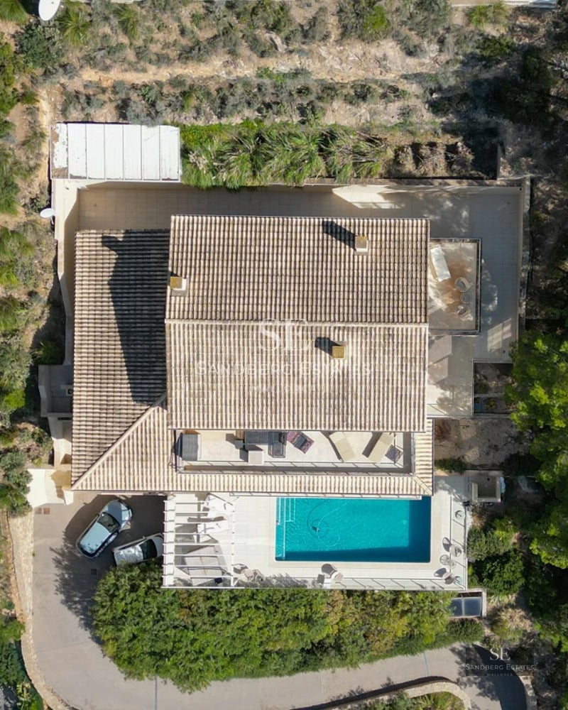 Exterior view of a modern villa featuring a pool, garden, and spacious terraces. Minimalist architecture with large windows and luxurious finishes.