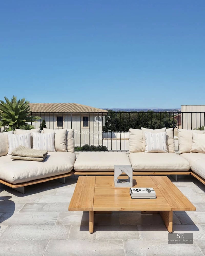 Spacious living room with large windows, sea views, modern furniture, and balcony access. Bright and airy.