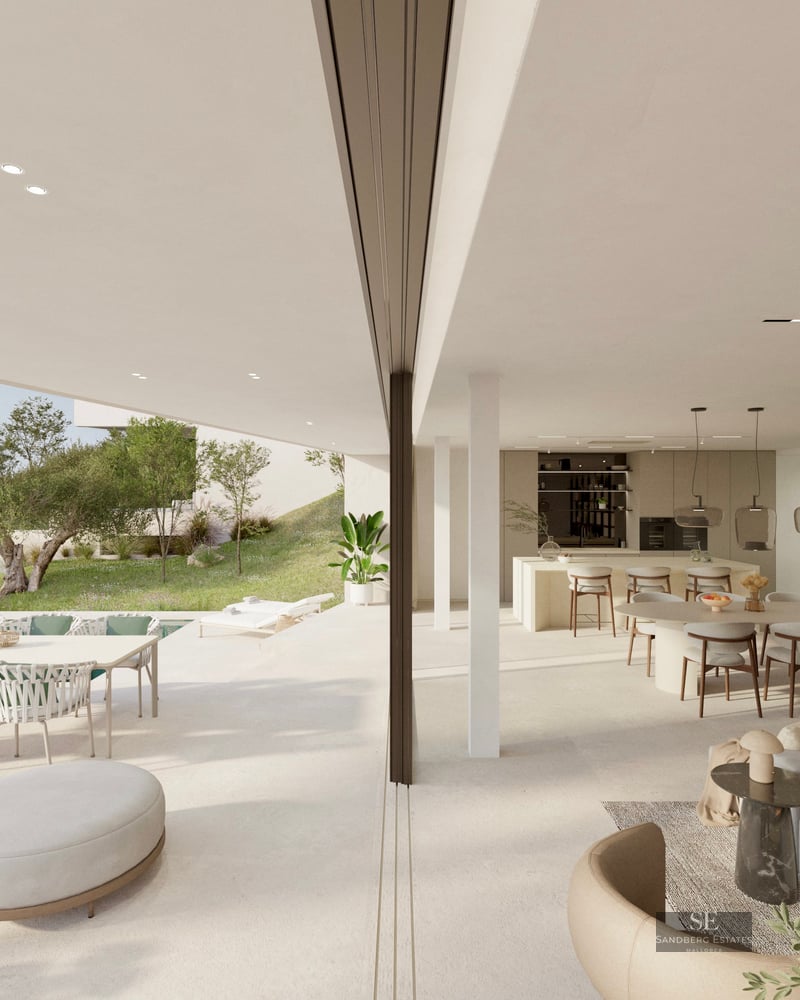 Bright, open-plan living and dining room merging with a spacious terrace overlooking the sea and coastline.