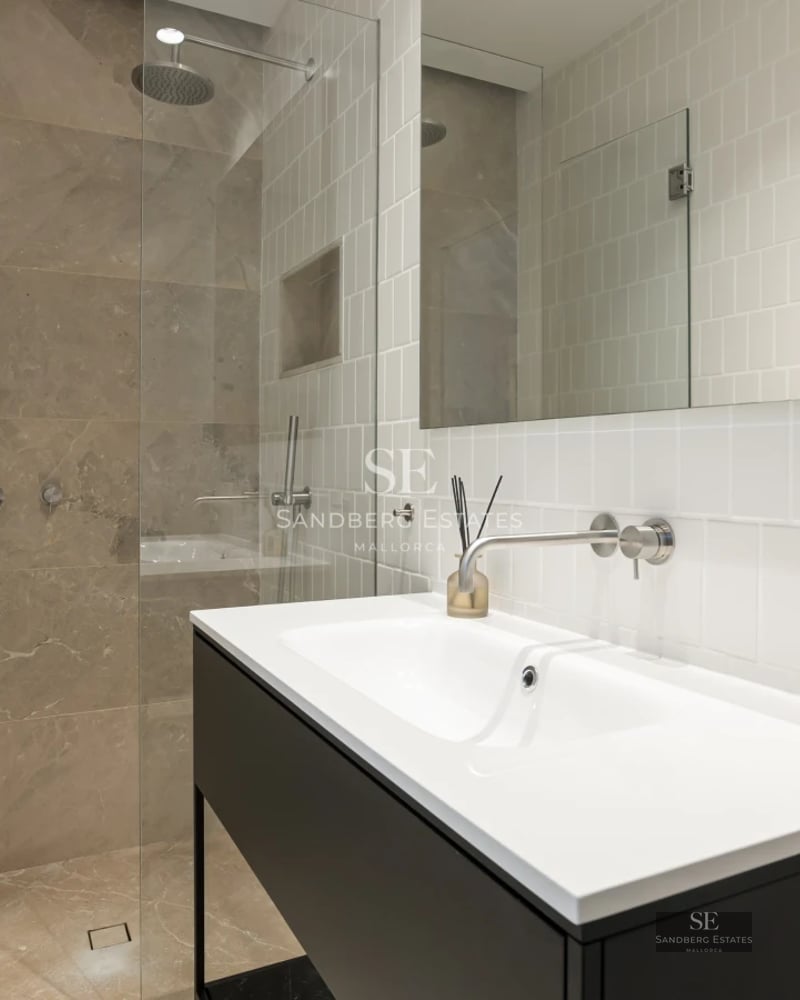 Exterior view of modern house with pool, manicured garden, and large windows reflecting sunlight.