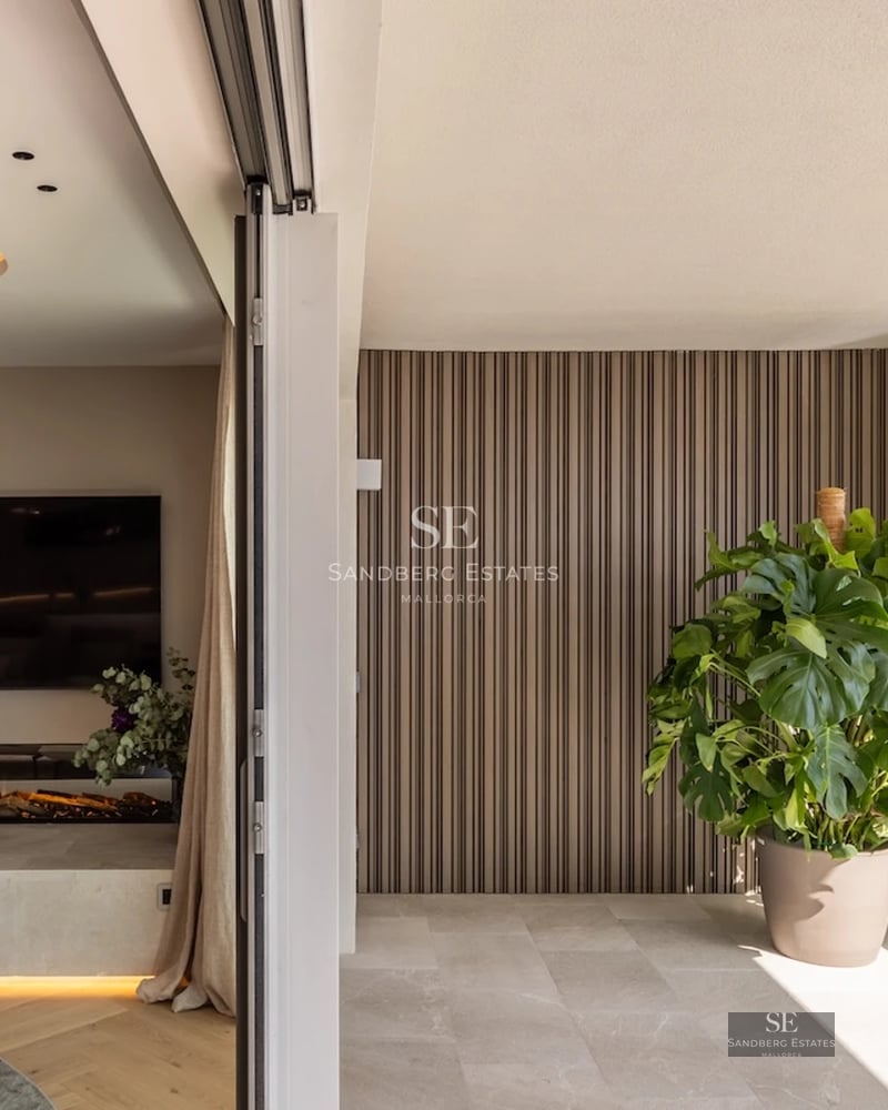 Terrace with sea view. Glass railing, light wood flooring, and modern furniture. Minimalist design with abundant natural light.