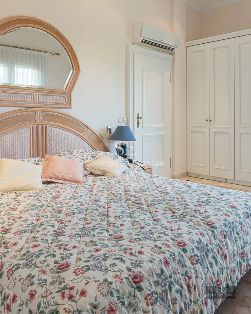 Exterior view of modern villa with infinity pool, lush garden, and minimalist architecture. Warm lighting and blue sky.