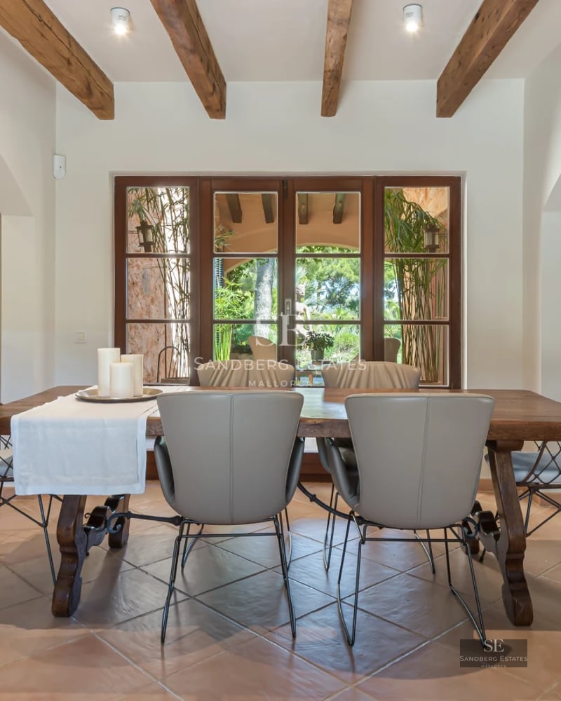 Exterior view of a modern villa with pool, large windows, minimalist design, and lush vegetation.