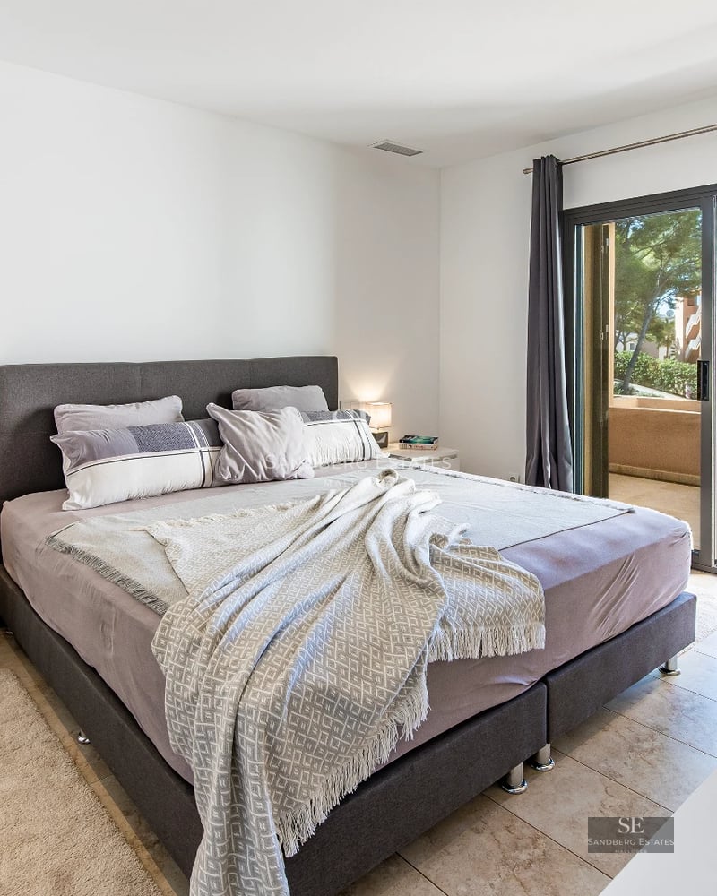 Large pool surrounded by a modern house with large windows and lush gardens. Contemporary and elegant architecture.