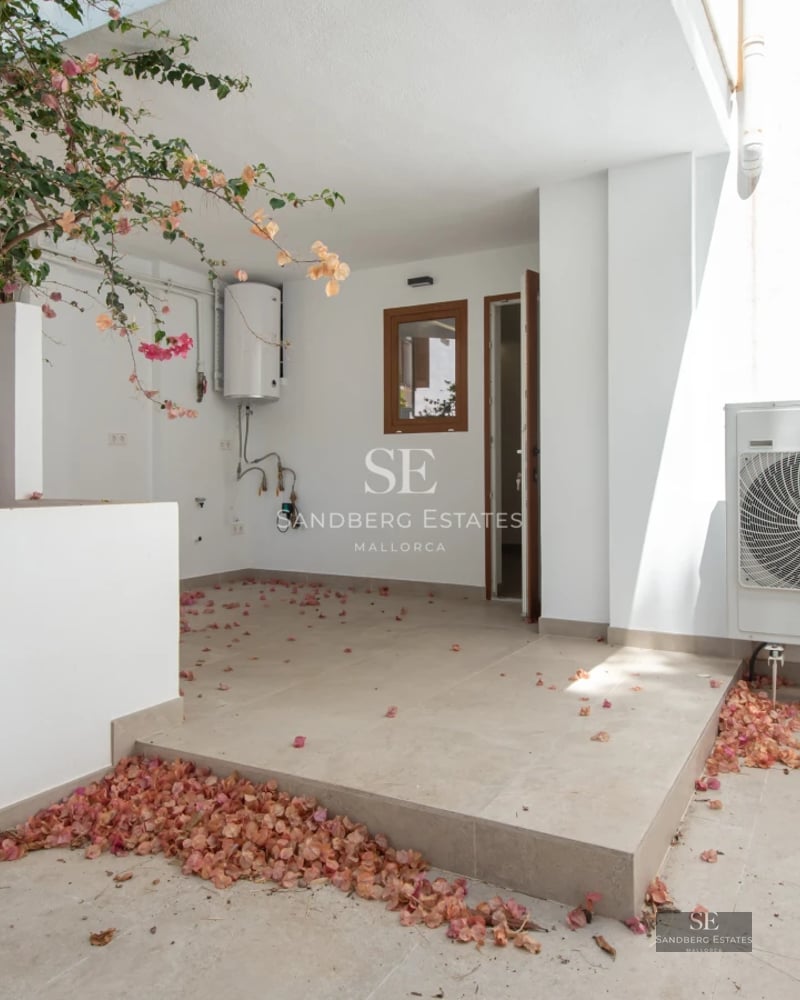 Spacious living room with fireplace, large windows, and terrace access with views. Elegant furniture and modern decor.