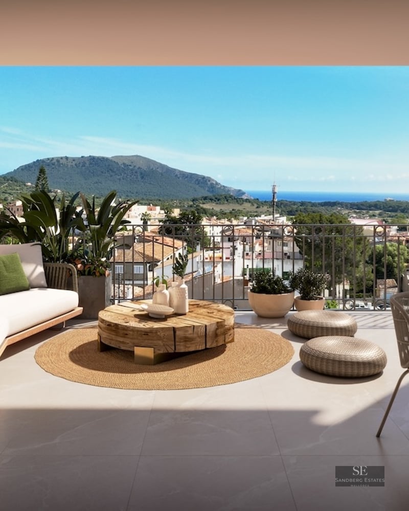 Covered terrace with designer lounge furniture, wooden coffee table, and expansive views of the sea and mountains.