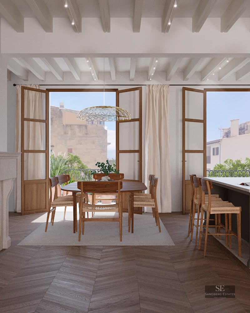Open-plan dining room with wood chevron floors, a classic stone fireplace, and French doors opening to a balcony.