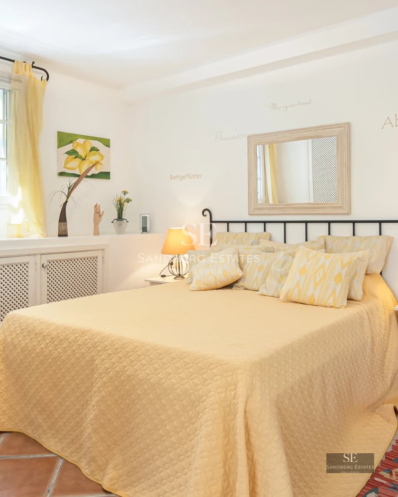 Spacious balcony with ocean views. Modern, minimalist furniture. Wood floors and glass railing. Lush green vegetation.