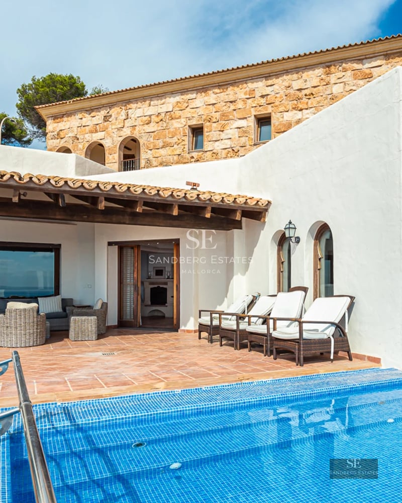 Vaste terrasse avec piscine à débordement et vue panoramique. Design moderne, mobilier d'extérieur élégant et végétation luxuriante.