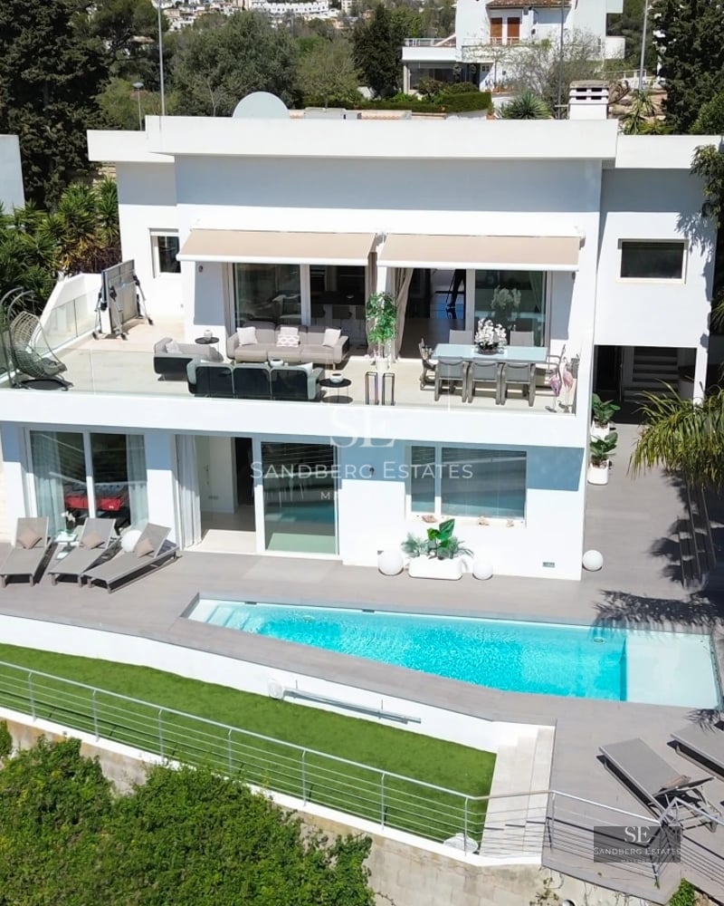 Infinity pool with sea views, modern sun loungers and lush vegetation. Minimalist and elegant design.