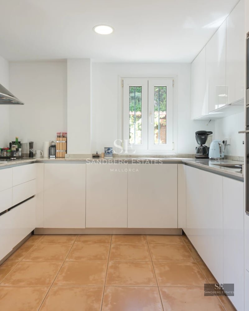 Spacious living room with panoramic windows, light wood floors, modern fireplace and minimalist decor with a sea view.