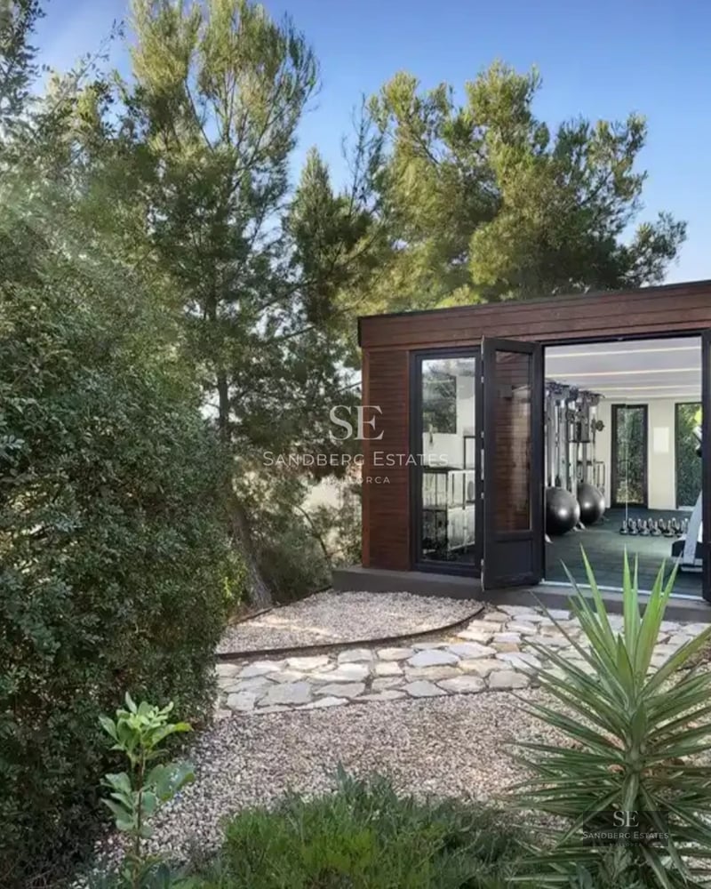 Spacious living room with floor-to-ceiling windows, modern furniture, sea view, and balcony. Bright and elegant design with natural touches.