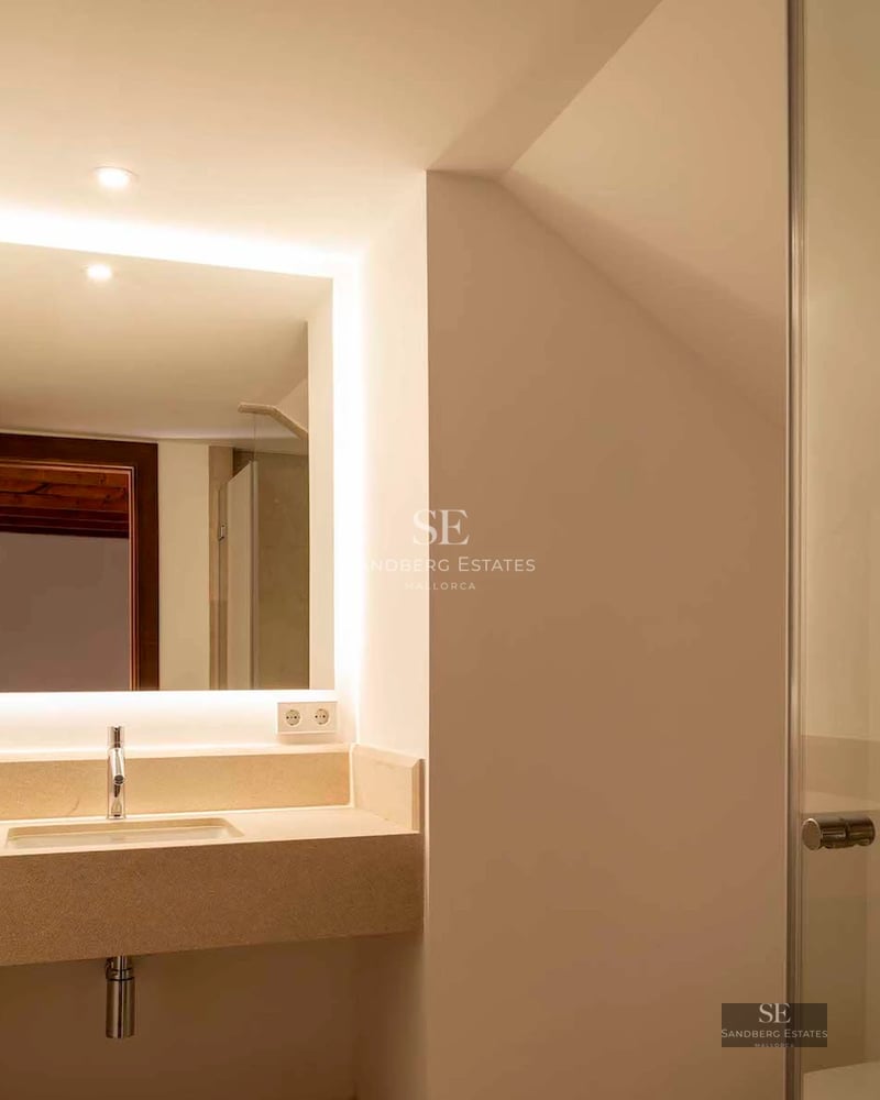 Spacious balcony overlooking the sea, modern outdoor furniture, wooden flooring, and glass railing. Contemporary and elegant design.