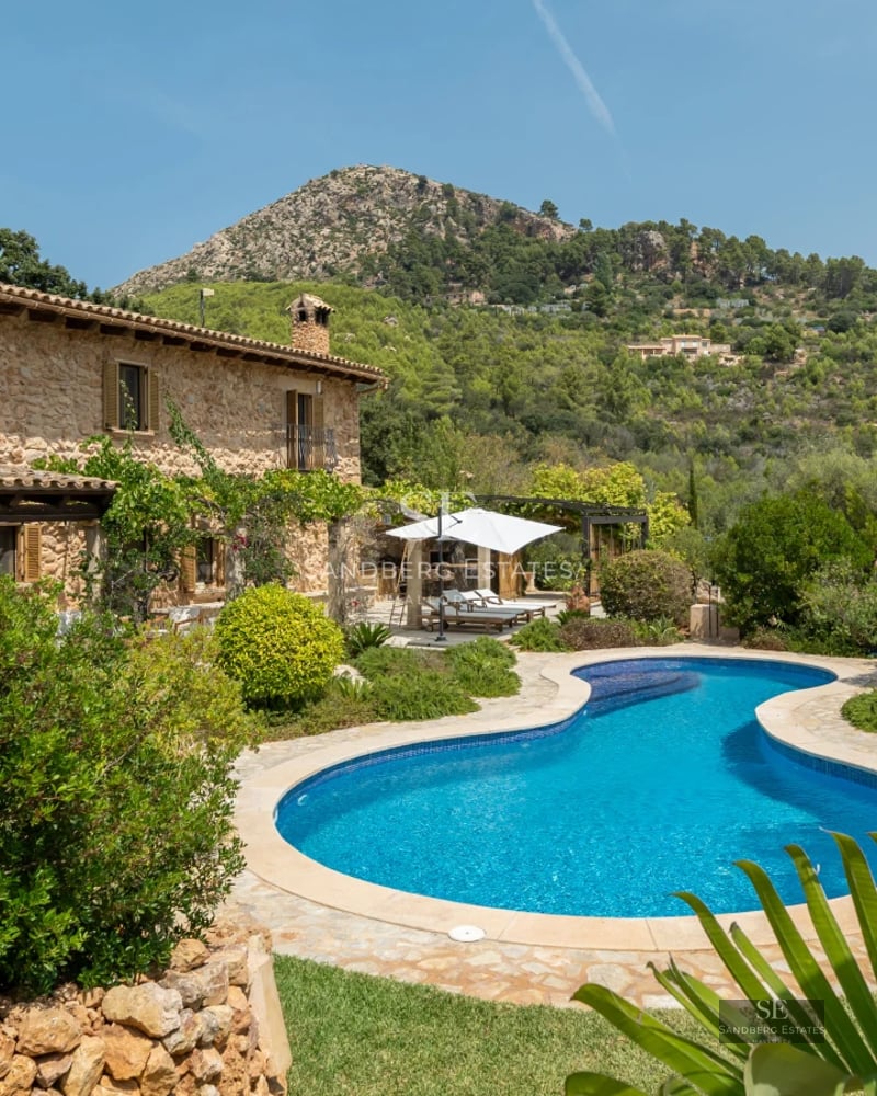 Modern exterior with infinity pool, wooden deck and large windows. Sleek, minimalist design. Green lawn.