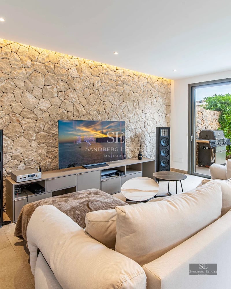 Exterior view of a modern villa featuring an infinity pool, lush garden, and contemporary architecture. Warm lighting.