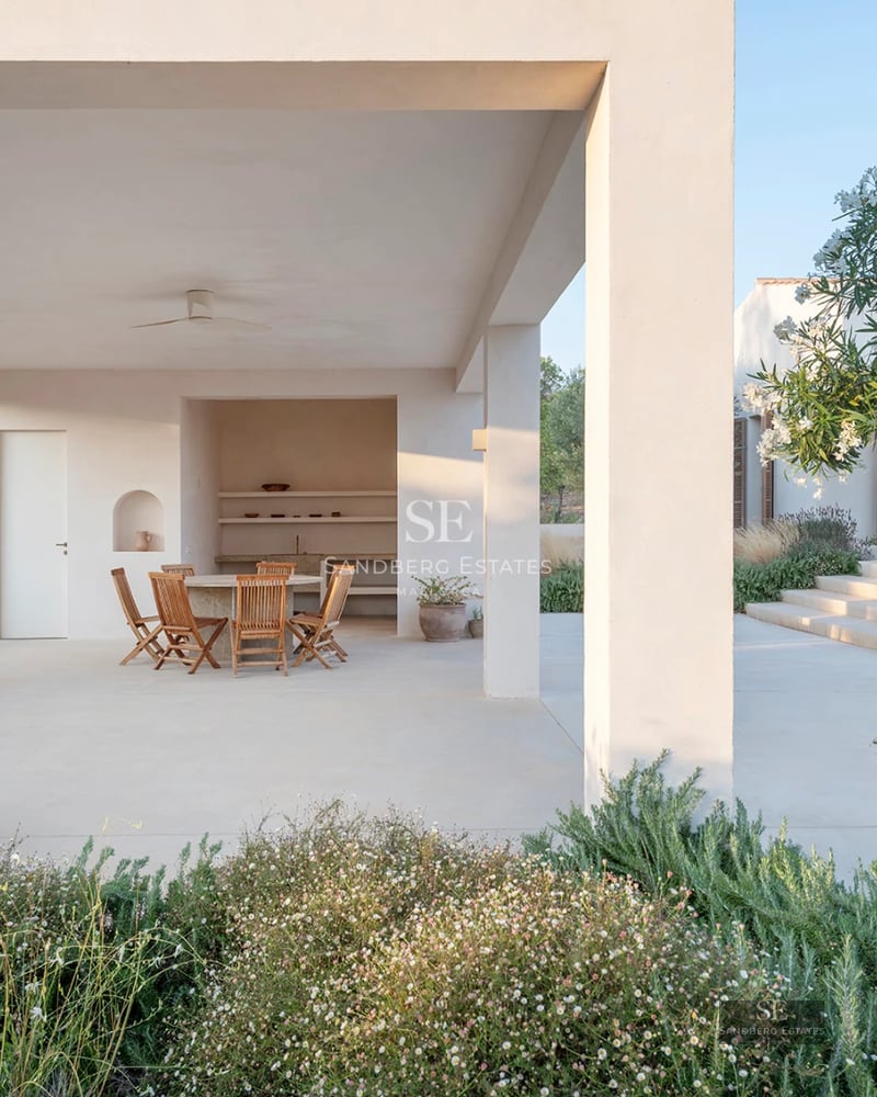 Modern exterior featuring a reflective pool, light stone facade, expansive windows, and lush gardens. Impeccable landscaping.