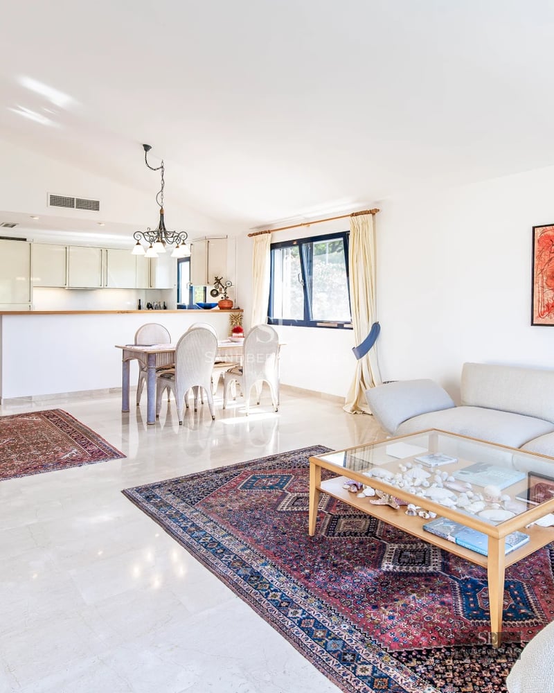 Exterior view of a modern villa featuring a pool, lush garden, and spacious terraces. Sleek and minimalist architectural design.